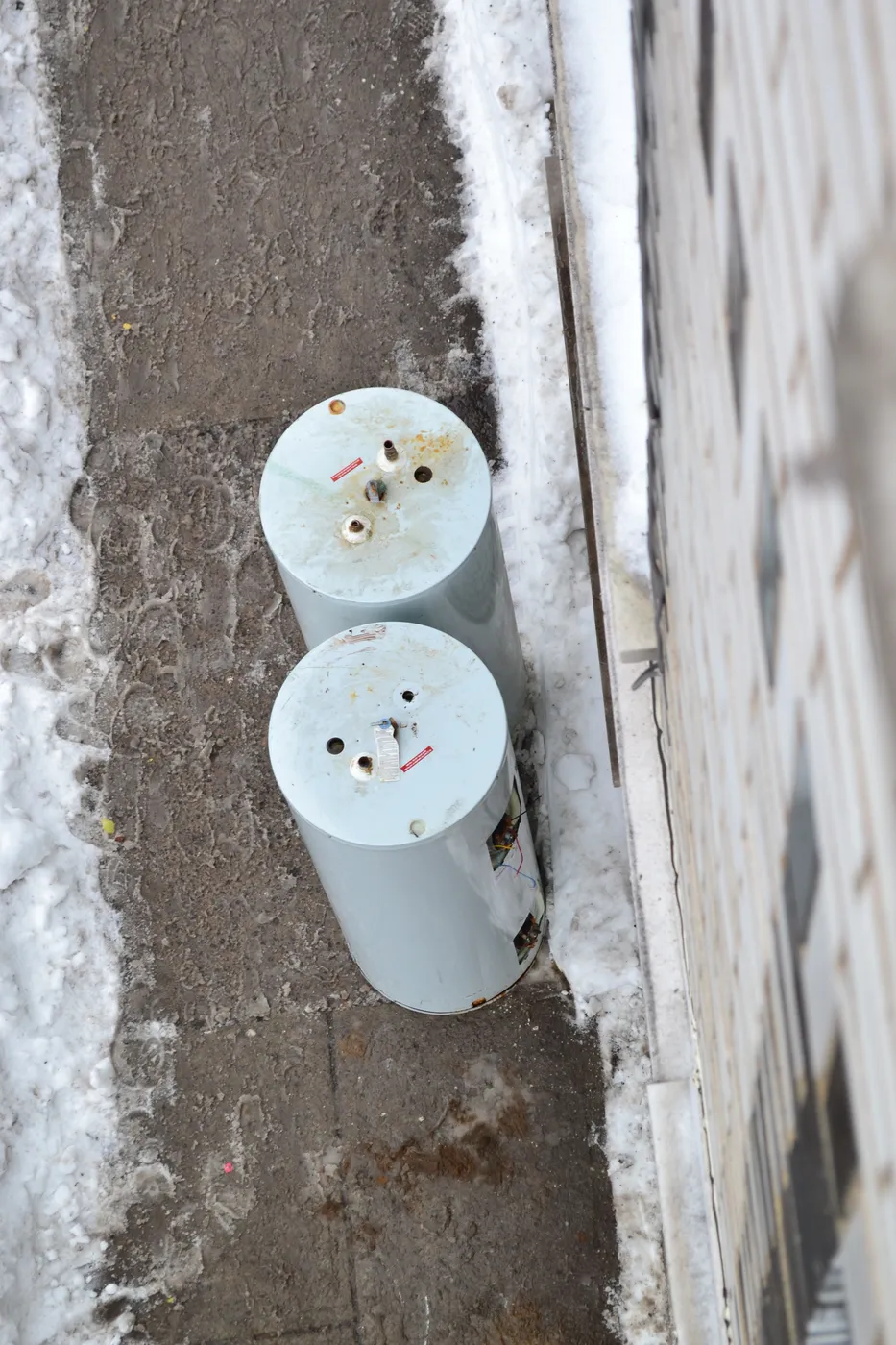 Old water heater tanks removed during a replacement job